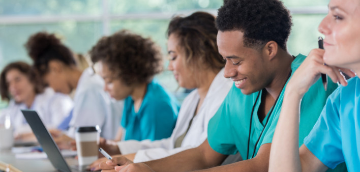 Diverse pre-med students take notes during class
