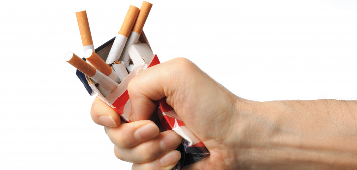 Hand crushing box of cigarettes