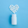 white bottle and white pills forming a heart