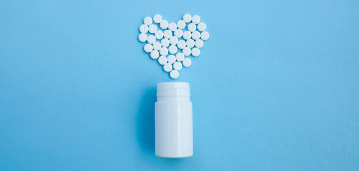 white bottle and white pills forming a heart