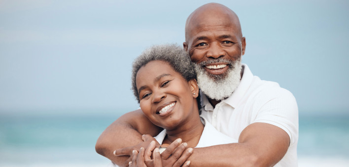 smiling man and woman embrace on beach