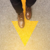 man's shoes and yellow arrow