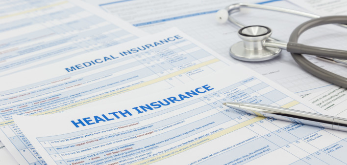Medical insurance application, silver pen and stethoscope. Legal law contract and health insurance concepts.