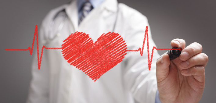 doctor in white coat drawing a red heart on glass