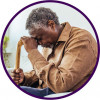 older black man depressed head on cane