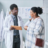 Young African American doctor consulting female patient