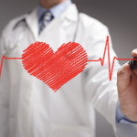 doctor in white coat drawing a red heart on glass