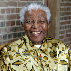 Late South African president Nelson Mandela smiles as he poses for a portrait in London.