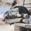 homeless man asleep on bench