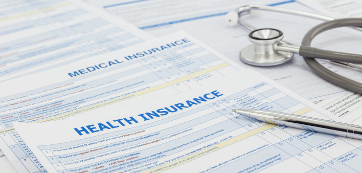 Medical insurance application, silver pen and stethoscope. Legal law contract and health insurance concepts.