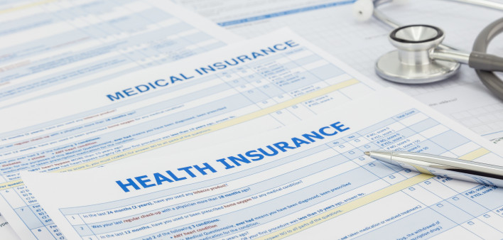 Medical insurance application, silver pen and stethoscope. Legal law contract and health insurance concepts.