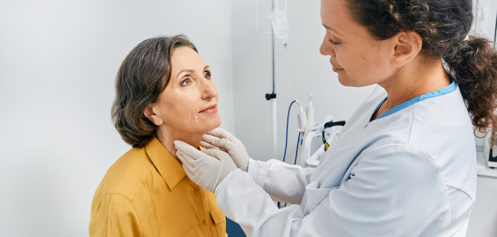doctor checking a patients thyroid