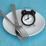 alarm clock on plate with fork and knife fastting diet