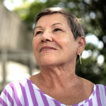 senior hispanic woman looking off into distance with a slight smile