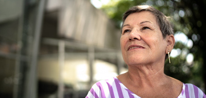 senior hispanic woman looking off into distance with a slight smile