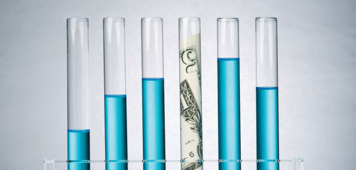 test tubes with blue liquid and money in one tube