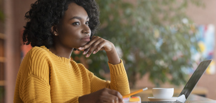 Thoughtful afro woman looking for new job online