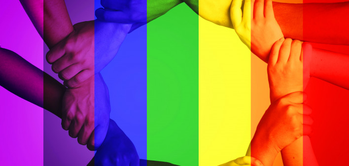 Cropped shot of unrecognizable people linking arms against a multi colored overlay