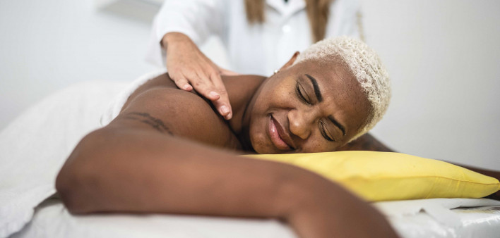 Mature woman getting massage at spa African American