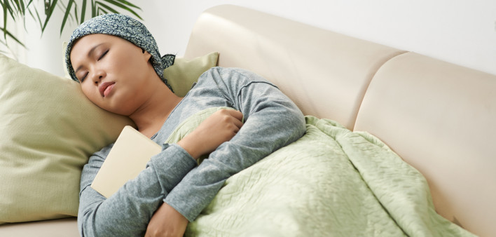 Asian woman with cancer sleeping on couch