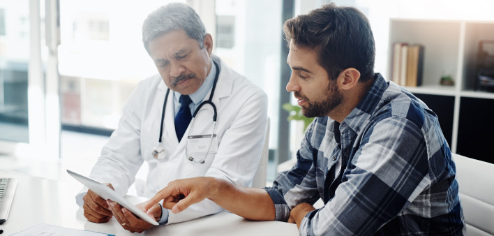 Cropped shot of a mature male doctor and patient having a discussion in the doctor's office before a checkup