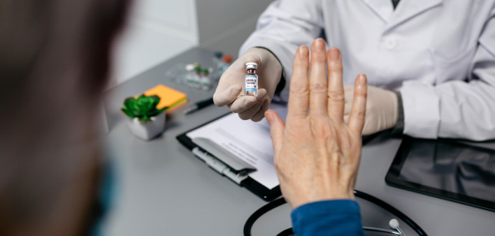 Female patient refusing the coronavirus vaccine offered by her doctor