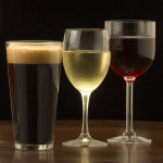 An assortment of glasses of wine and beer including a classic pilsner flute, a sparkling wine glass, an American half pint glass, a weizen or wheat beer glass, an American pint glass, a white wine glass, and a red wine glass.