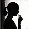 silohoutte woman taking a pill