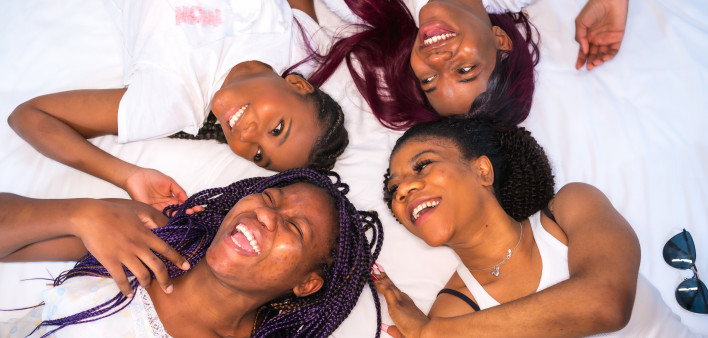 Black women Lifestyle of friends in a hotel bed, friends of black ethnicity. Having fun and looking at each other.