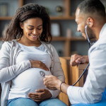 Pregnant african american woman visiting doctor gynecologist