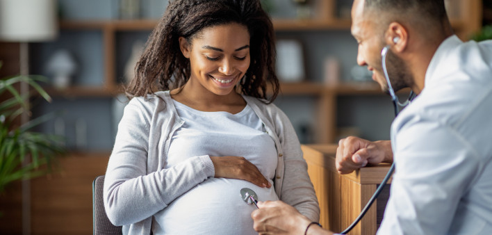Pregnant african american woman visiting doctor gynecologist