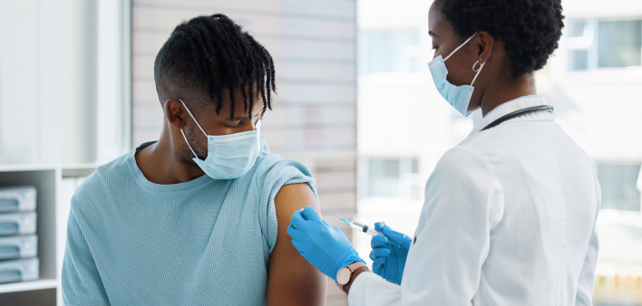 Young man being given an injection vaccine