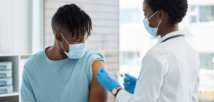 Young man being given an injection vaccine
