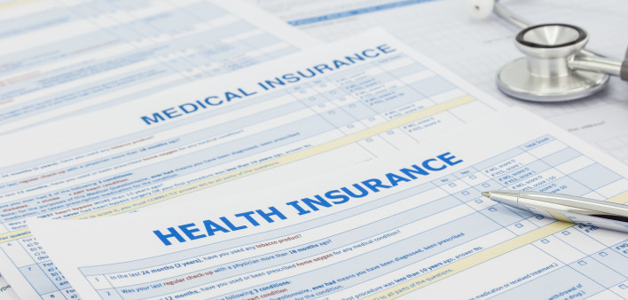 Medical insurance application, silver pen and stethoscope. Legal law contract and health insurance concepts.