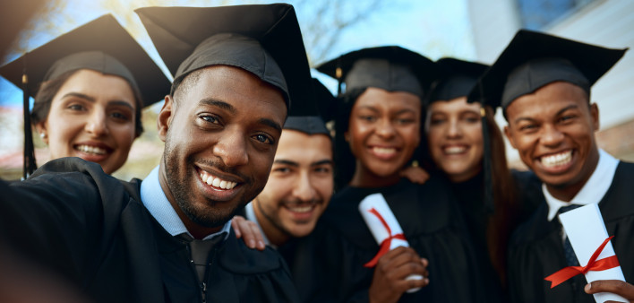 Portrait of a group of students taking selfies on graduation day