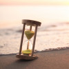 hourglass on the beach at waters edge
