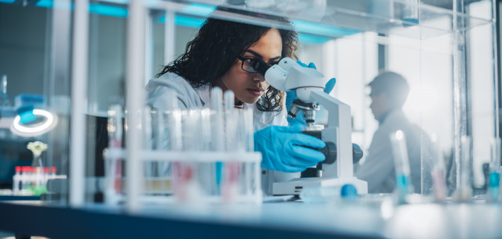Medical Science Laboratory: Portrait of Beautiful Black Scientist Looking Under Microscope