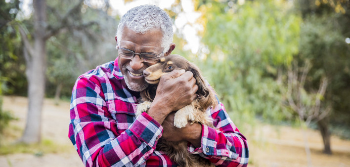 older man holding a dog