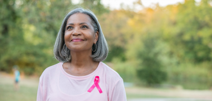 Beautiful senior woman smiles while walking for breast cancer awareness