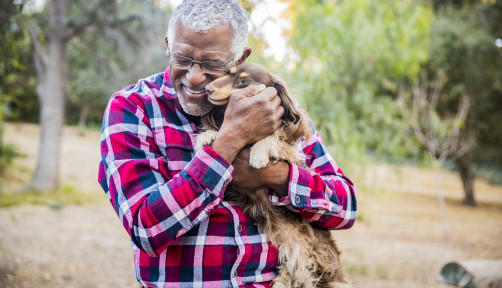 older man holding a dog