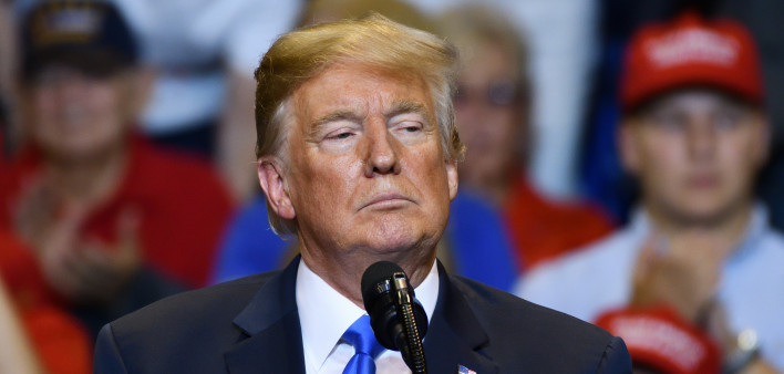 President Donald Trump with a serious look as he delivers a speech at a campaign rally held at the Mohegan Sun Arena.