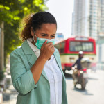 African American women wearing masks face dust Smoke problems on the road in the capital. stock photo City, Coughing, Pollution, Adult, Adults Only