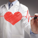 doctor in white coat drawing a red heart on glass