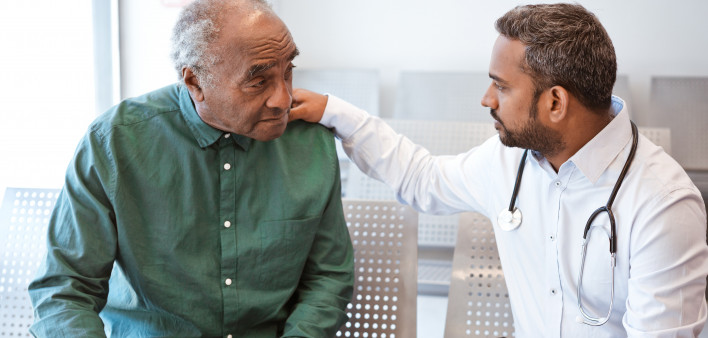 Doctor consoling sad senior male patient