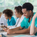 Diverse pre-med students take notes during class