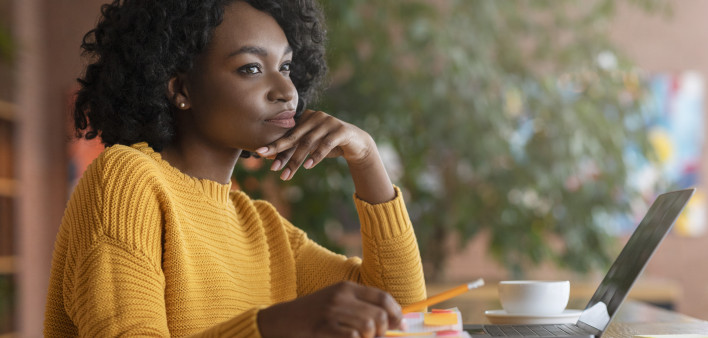 Thoughtful afro woman looking for new job online