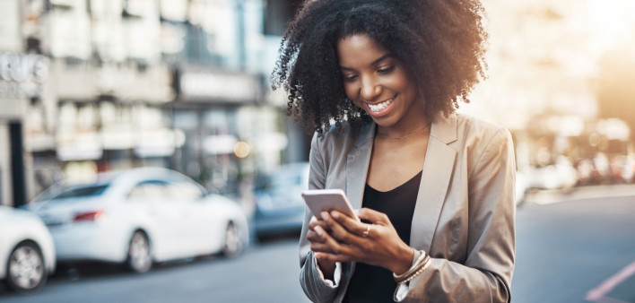 Shot of a young businesswoman using a cellphone in the city