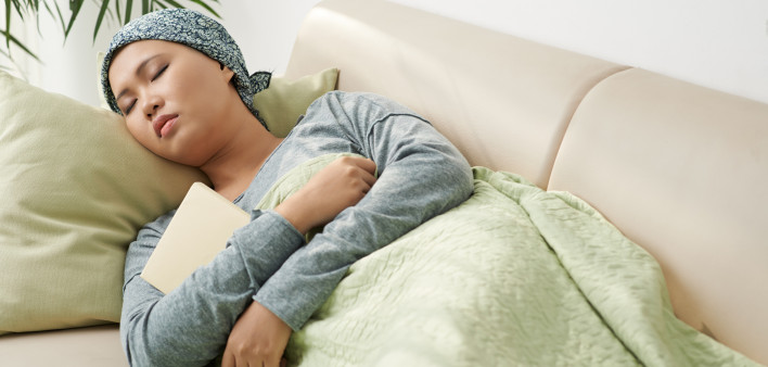 Asian woman with cancer sleeping on couch