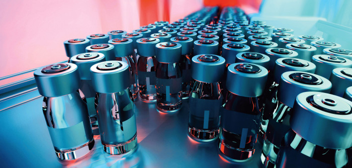 vials of vaccine on assembly line factory