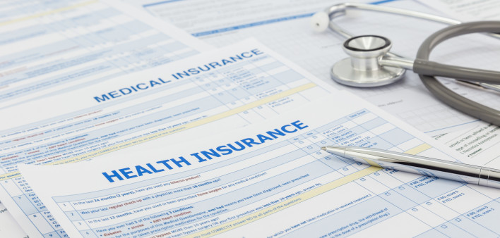 Medical insurance application, silver pen and stethoscope. Legal law contract and health insurance concepts.